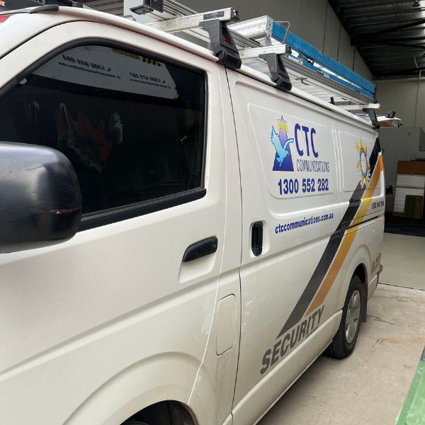 White CTC Communications installation van with ladders on roof rack and "SECURITY" text.